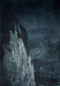 Mystery surrounds a lonely outcropping in ski country. Approx. 28” x 20" handcrafted alternative process print (antracotypia (resinotype) on white plastic board; natural indigo pigment; wood frame, no glass). Edition #1/10. Signed original print offered by GALLERY5X7.